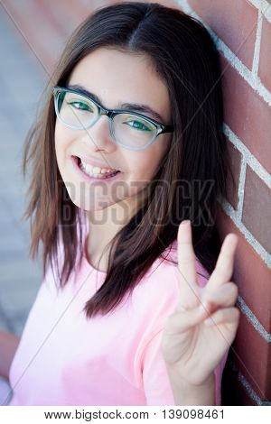 Preteenager girl next to a red brick wall with nice expression