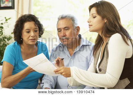 Senior Couple With Financial Advisor At Home