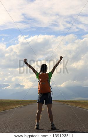 young woman hiker open arms at beautiful mountain trail