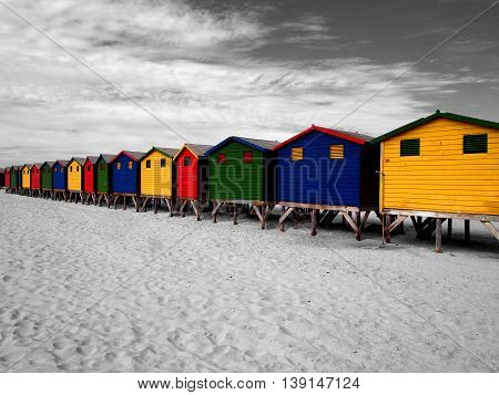 The row of wooden brightly colored huts on Sunrise Beach. Atlantic ocean. Cape Town. Muizenberg. South Africa. Modern architecture art.