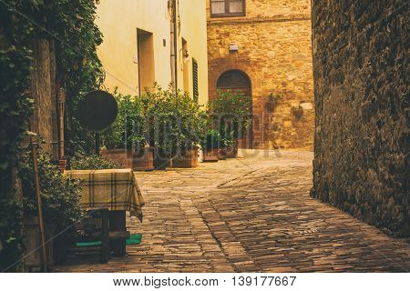Empty street of small Tuscany town San Quirico d'Orcia in the morning fog, romantic travel vintage hipster european italy background