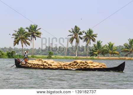 Allepey, Kerala, India March 31, 2015: Indian man transport dwell with rice for boats. backwaters canoe in state, .