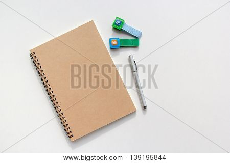 Brown book closed and pen beside with color clips