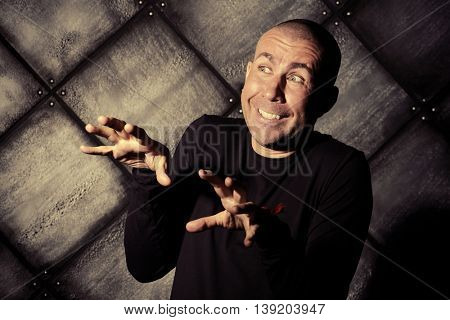 Portrait of a funny man in black clothes over grunge background.
