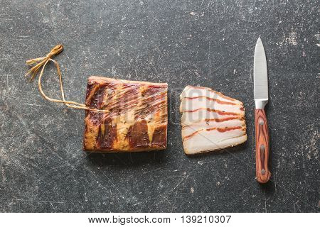Fresh smooked bacon on old kitchen table.