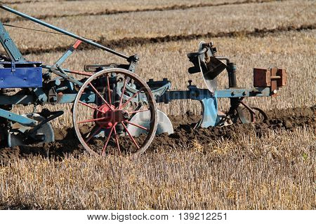 A Classic Agricultural Farming Plough Cutting a Furrow.