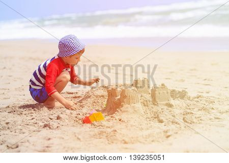 little boy play with sand on summer tropical beach