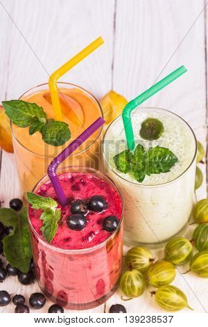 Various smoothies in glasses on a wooden table