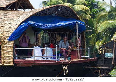 Allepey, Kerala, India, March 31, 2015: Unidentified indian man and tourists are sailing in houseboat on backwaters Allapuzha city