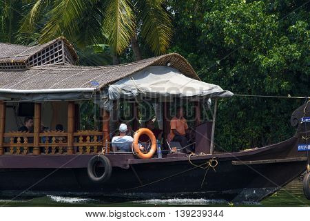 Allepey, Kerala, India, March 31, 2015: Unidentified indian man and tourists are sailing in houseboat on backwaters Allapuzha city