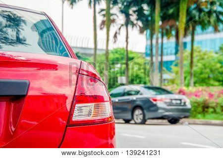 red and black cars parked beside the road.