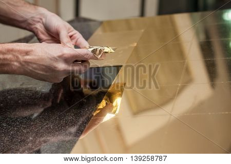 Master works with a thin gold leaf pieces on glass hands in the center of the frame