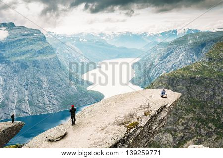 Odda, Norway - August 04, 2014: Young People Are Photographed Standing On A Rock Trolltunga - Troll Tongue In Norway. View From Rock Trolltunga - Troll Tongue.
