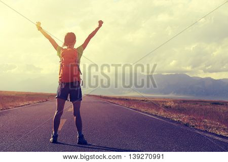 young woman hiker open arms at beautiful mountain trail