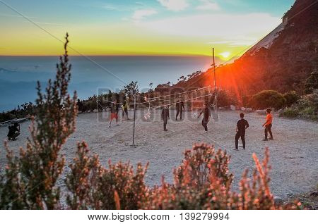Mount Kinabalu Sabah Malaysia:March 12,2016:Undentified group of climber playing volleyball at Laban Rata built at 3,273 meter above sea level with sunset background.