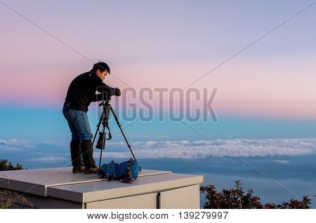 Ranau,Sabah,Malaysia-March 12,2016:Silhouette of a photographer framing a shot, taking pictures at beautiful sunset on Laban Rata.This place is for climbers to rest before summiting the mount peak.