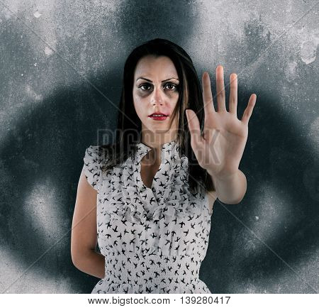 Scared woman with bruises and scratches with shadow of a man behind her