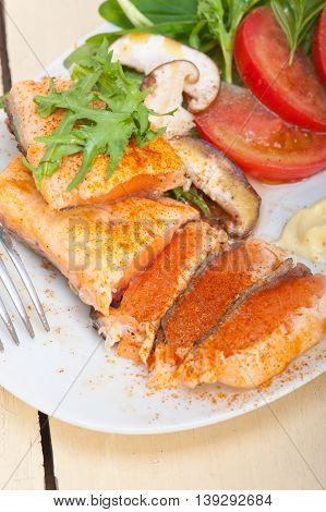 close up image of grilled samon filet with vegetables salad