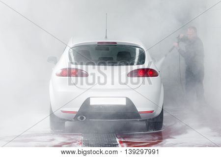 Automobile in car wash, water splatter background. Cleaness, care, hobby concept