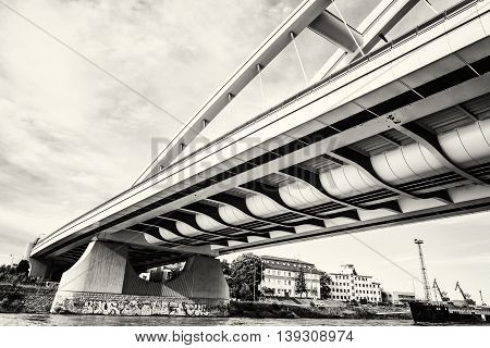 Modern Apollo bridge in Bratislava Slovak republic. Architectural theme. Danube river. Black and white photo. Ship transportation. Infrastructure theme.