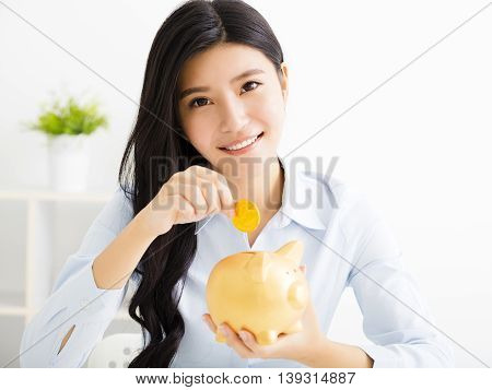 young smiling asian business woman with piggybank