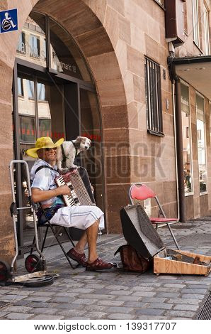 Nurnberg Bavaria / Germany - July 19th 2014: photo of a street musician playing his piano accordion on the streets of Nurnberg