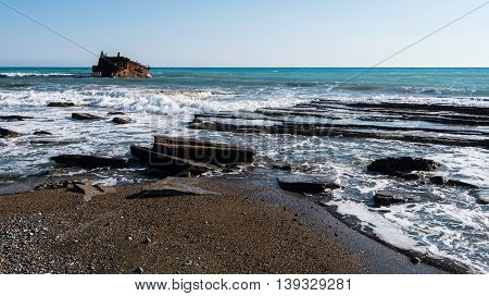 Shipwreck of an abandoned ship on a rocky coast at Akrotiri Beach in Cyprus