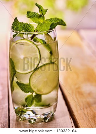 Alcohol country cocktail. On wooden boards is glass with alcohol cocktail and ice cubes.Drink one hundred eighty eight cocktail mohito with slice lime and mint leaf. Country life. Boards background.