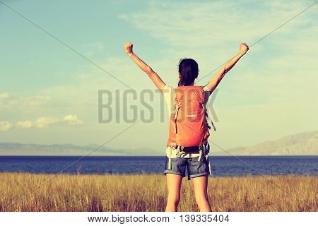 young woman hiker open arms to beautiful landscape