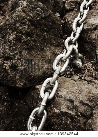 Eye Bolt With Iron Chain Anchored Into Sandstone Rock. Twisted Chain
