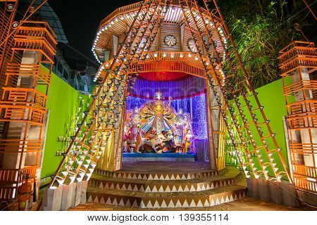 KOLKATA INDIA - OCTOBER 18 2015 : Night image of decorated Durga Puja pandal shot at colored light at Kolkata West Bengal India. Durga Puja is biggest religious festival of Hinduism.