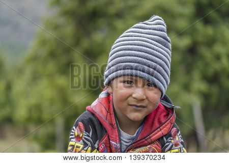 AZUAY, ECUADOR, OCTOBER - 2015 - Portrait of indigenous ecuadorian kid with serious expression in Azuay province Ecuador.