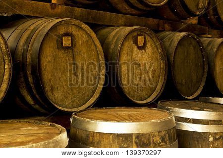 Wine barrels stacked in the old cellar of the winery.