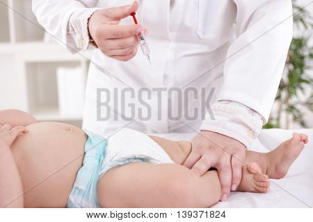 Female pediatrician with baby vaccination, health concept