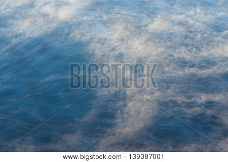 Water vapor on surface of cold icy water at sunny cold winter day