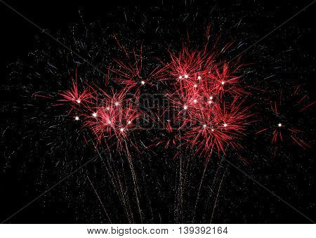 Red fireworks explode during 4th of July Holiday celebration