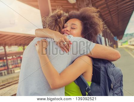 Man meeting his girlfriend from her trip at the train station. Close up.