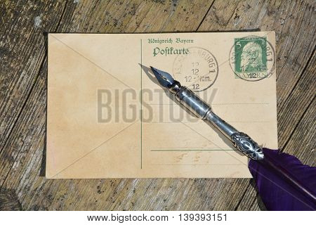 old blank vintage postcard with old stamp is on old wood with nib