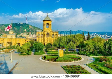 The Sameba Cathedral boasts beautiful garden. with colorful flower beds and trimmed bushes Tbilisi Georgia.