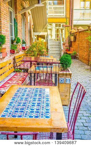 TBILISI GEORGIA - MAY 29 2016: The beautiful table decorated with the tiled screen with bright ornament on May 29 in Tbilisi.