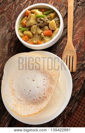 Overhead view-Kerala cuisine-Soft Appam served with hearty mutton stew