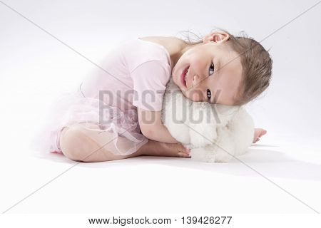 Portrait of Cute Caucasian Female Kid Sitting Together with Plush Toy and Smiling.Horizontral Image Composition