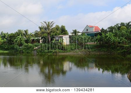 Vietnamese countryside with house next to the fishing pond