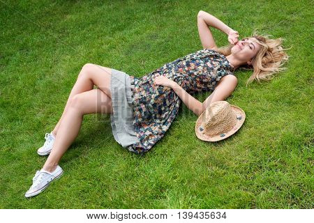Young woman relaxing on a beautiful green meadow