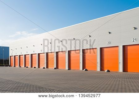 ENSCHEDE, NETHERLANDS - NOVEMBER 28, 2015: Exterior of a commercial warehouse with orange roller doors