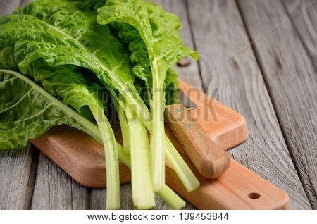Fresh green chard leaves on wooden background, selective focus, copy space