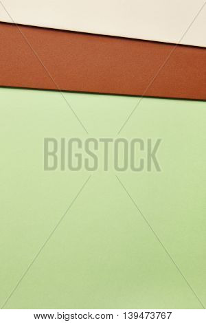 Colored cardboards background in green brown beige tone. Copy space. Vertical