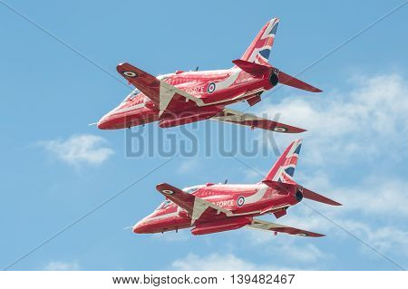 FARNBOROUGH, UK - JULY 17: Low-level flypast by the Red Arrows aerobatic display team at an aviation event at Farnborough, UK on July 17, 2016
