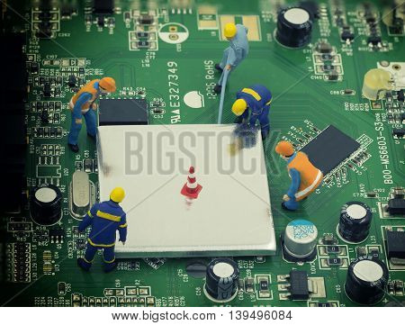 group of mini mechanic work on mainboard and CPU they try to open chip for repair - can use to display or montage on product