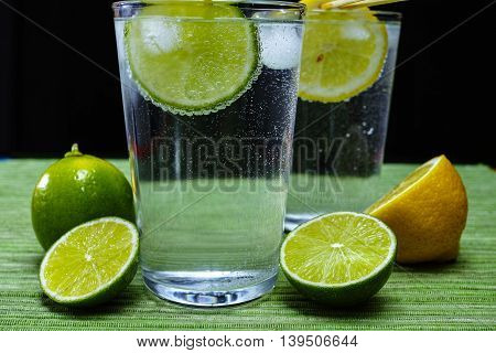 Glass with cold sparkling mineral water lime and lemon seltzer
